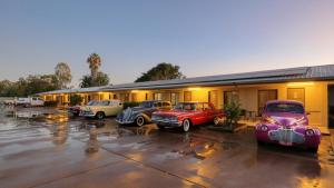 un grupo de coches aparcados delante de un edificio en Merino Motor Inn, en Saint George