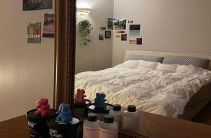 1 dormitorio con cama, espejo y botellas en una mesa en Linden Guesthouse, en Jeju