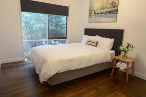 een slaapkamer met een groot bed en een raam bij Rivendell in Merrijig