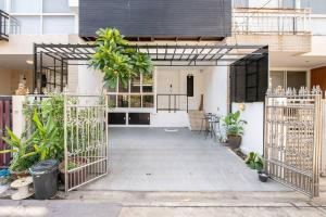 une porte ouverte menant à un bâtiment avec des plantes dans l'établissement 420 House- up to 10 guests in central Bangkok., à Bangkok