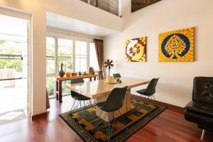 a dining room with a wooden table and chairs at 420 House- up to 10 guests in central Bangkok. in Bangkok
