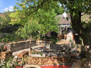 a garden with a stone wall and a tree at Ferienhaus Donnerskirchen in Donnerskirchen