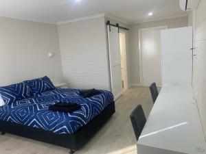 Un dormitorio con una cama y una mesa con sillas. en Pingelly Retreat Motel, en Pingelly