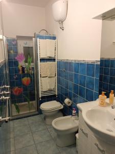Baño de azulejos azules con aseo y lavamanos en appartamento in firenze la lamma, en Florencia