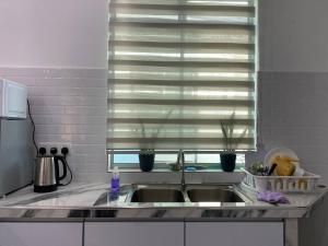 a kitchen counter with a sink and a window at Kuala Kedah Pool Cottage in Kuala Kedah +24 photos