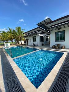 a swimming pool in front of a house at Kuala Kedah Pool Cottage in Kuala Kedah