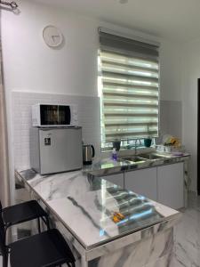 a kitchen with a counter top with a microwave at Kuala Kedah Pool Cottage in Kuala Kedah