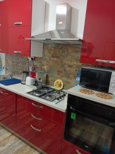 una cucina con armadi rossi e un piano cottura. di appartamento in firenze la lamma a Firenze