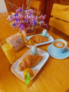 einen Tisch mit zwei Croissants und einer Tasse Kaffee in der Unterkunft YangShuo Eden Inn in Yangshuo