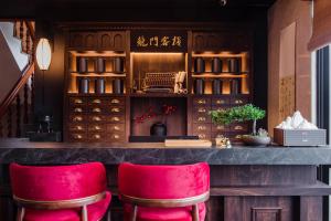 un bar con taburetes rojos en un restaurante en H& Jiufen The Dragon Inn, en Jiufen