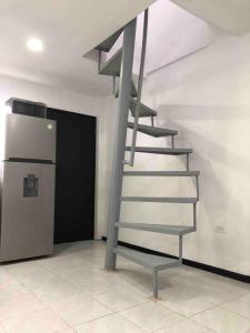 a metal spiral staircase in a room with a refrigerator at D2 Hermoso condominio privado in Tijuana