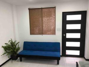 een blauwe bank in een kamer met een raam bij D2 Hermoso condominio privado in Tijuana