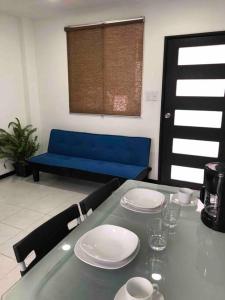a table with plates and a blue couch in a room at D2 Hermoso condominio privado in Tijuana