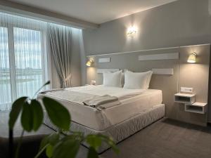 a bedroom with a bed and a large window at Del Ponte in Svilengrad