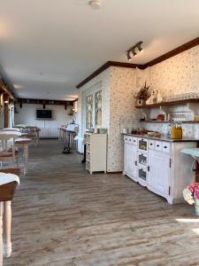 a large kitchen with white cabinets and a table at Hotel Gode Tied in Zingst