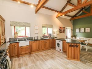 a kitchen with wooden cabinets and a washer and dryer at The Arches Larklands in Richmond