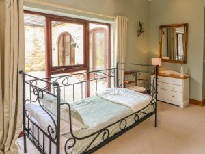 1 dormitorio con cama de hierro forjado y ventana en The Arches Larklands en Richmond
