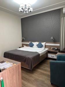 ein Schlafzimmer mit einem großen Bett mit blauen Kissen in der Unterkunft Gоlden Dragon Villa Hotel in Bischkek