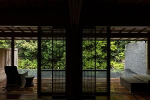 ein Wohnzimmer mit Glasschiebetüren und Blick auf eine Terrasse in der Unterkunft ABBA Resorts Izu - Zagyosoh in Ito