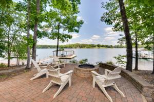 un patio con sillas y una hoguera junto a un lago en Seneca Lakefront Vacation Rental with Boat Dock!, en Seneca