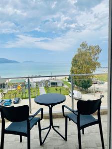 a table and chairs on a balcony with a view of the beach at Maor Hotel in Vlorë