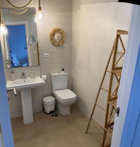 a bathroom with a toilet and a sink and a mirror at Apartamento La Sirenita in Rota