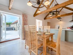 a kitchen and dining room with a wooden table and chairs at Barnyard in Chetnole