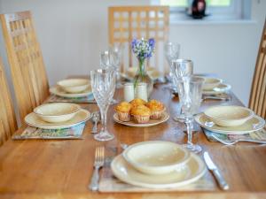 a wooden table with plates and glasses and food on it at Barnyard in Chetnole