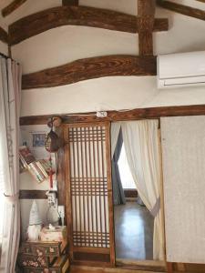 Habitación con puerta abierta a una habitación con techo en Gugangjae Hanok Stay, en Jeonju