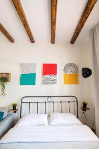 um quarto com uma cama e algumas fotografias na parede em Cozy House Old Town Xanthi - MenoHomes 1 em Xanthi