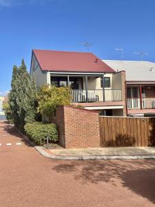 uma casa com uma parede de tijolos e uma cerca em Super spacious Fremantle Villa 3 Bedrooms 3 Bathrooms em Fremantle