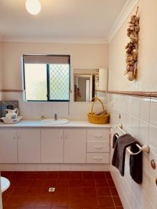 a white bathroom with a sink and a mirror at Villa 11 in Fremantle
