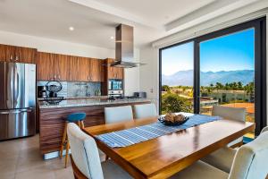 a kitchen and dining room with a table and a large window at Portosanto 502 in Puerto Vallarta
