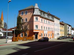 un bâtiment dans une rue avec une voiture garée devant elle dans l'établissement Hotel Rosenheimer Hof, à Traunstein