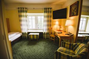 um quarto de hotel com um quarto com uma secretária e uma cama em Hotel Rosenheimer Hof em Traunstein