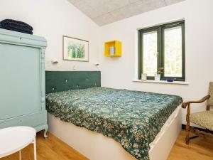 um quarto com uma cama, uma cadeira e uma janela em Holiday home Sæby CXXV em Sæby