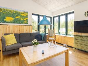 uma sala de estar com um sofá e uma mesa em Holiday home Sæby CXXV em Sæby