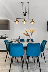 a dining room with a table and blue chairs at Cozy Special City Center - Old Town Apartment with terrace in Bucharest