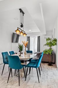 une salle à manger avec une table et des chaises bleues dans l'établissement Old Town Hideaway - 5 Min Walk to Palace of Parliament and Old City - Best Neighborhood, à Bucarest