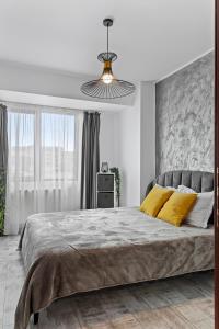 1 dormitorio con 1 cama grande con almohadas amarillas en Cozy Special City Center - Old Town Apartment with terrace en Bucarest