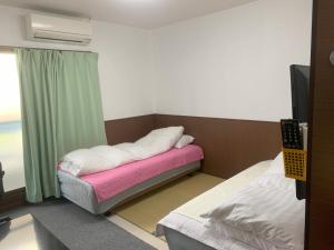 Habitación pequeña con cama y ventana en Oyama Guesthouse Kyoto, en Kioto
