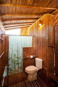 ein Bad mit einem WC und einer Bambusmauer in der Unterkunft Phuree Hut in Ko Phayam