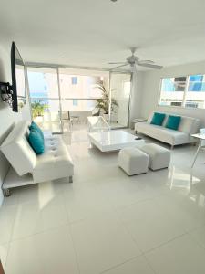 ein Wohnzimmer mit weißen Möbeln und blauen Kissen in der Unterkunft 3tc16 Apartment In Cartagena In Front Of The With Air Conditioning And Wifi in Cartagena de Indias