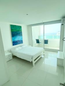 ein weißes Schlafzimmer mit einem Bett und einem großen Fenster in der Unterkunft 3tc16 Apartment In Cartagena In Front Of The With Air Conditioning And Wifi in Cartagena de Indias