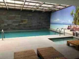 une grande piscine intérieure avec un grand écran dans l'établissement Cómodo departamento Cerca de Metro, à Santiago