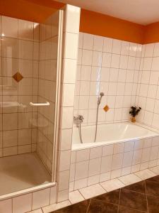 a bathroom with a shower and a bath tub and a tub at Hotel Rosenheimer Hof in Traunstein