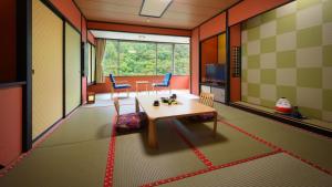 een woonkamer met een tafel en stoelen in een kamer bij Ashinomaki Grand Hotel in Aizuwakamatsu