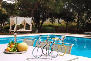 a table with fruit on it next to a pool at Villa Oasis with Large Pool Athenian Riviera Lagonissi in Lagonissi