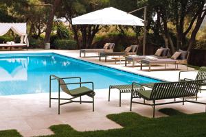 a swimming pool with chairs and an umbrella at Villa Oasis with Large Pool Athenian Riviera Lagonissi in Lagonissi