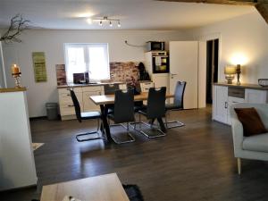 - une cuisine et une salle à manger avec une table et des chaises dans l'établissement FeWo Fuchsbau mit Dampfdusche und Kamin, à Bad Harzburg